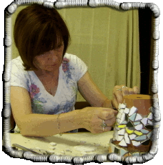 Jill working on her second artwork, applying mosaic to clay flower pot